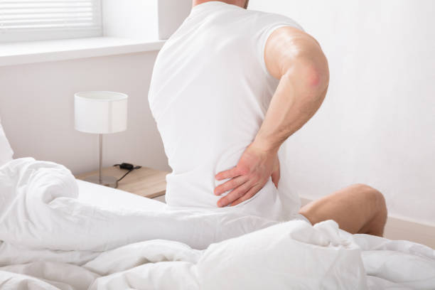 istock Man Sitting On Bed Having Back Pain 928074424