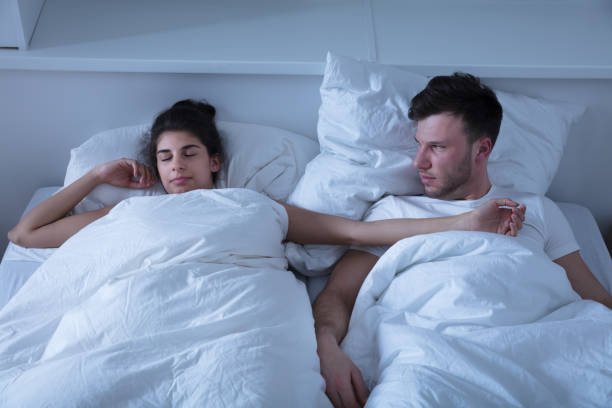 istock Angry Man Looking At Her Wife Sleeping On Bed 928074440