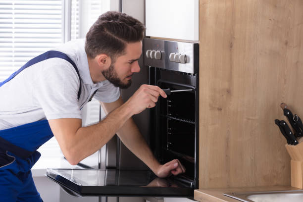 istock Electrician Repairing Oven With Screwdriver 928076836