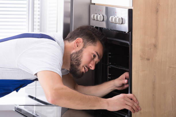 istock Electrician Repairing Oven With Screwdriver 928076848