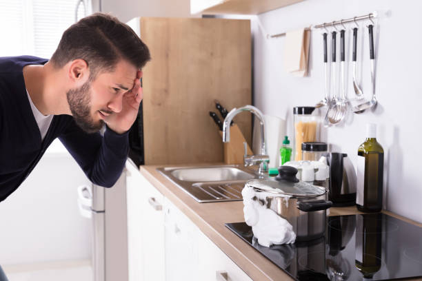 istock Man Looking At Spilling Out Boiled Milk From Utensil 928077426