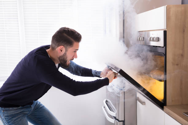istock Shocked Man Looking At Burnt Cookies In Oven 928077460
