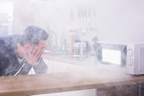 istock Man Looking At Fire Coming From Microwave Oven 928077476
