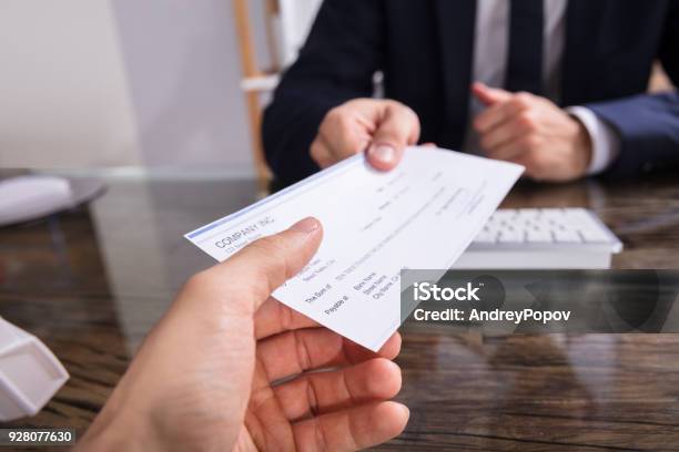 Businessperson Giving Cheque To Colleague Stock Photo - Download Image Now - Check - Financial Item, Wages, Paying
