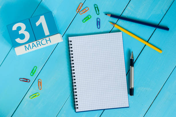 March 31st. Day 31 of month, calendar on blue wooden table background with notepad. Spring time, empty space for text March 31st. Day 31 of month, calendar on blue wooden table background with notepad. Spring time, empty space for text. number 31 stock pictures, royalty-free photos & images
