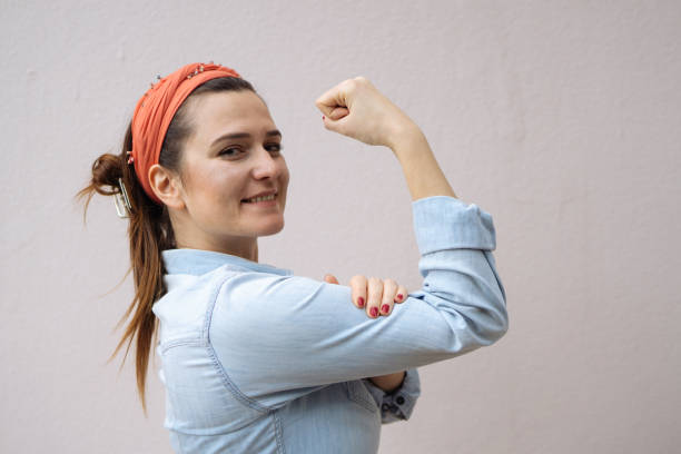 joven muestra su brazo fuerte - human muscle women bicep girl power fotografías e imágenes de stock