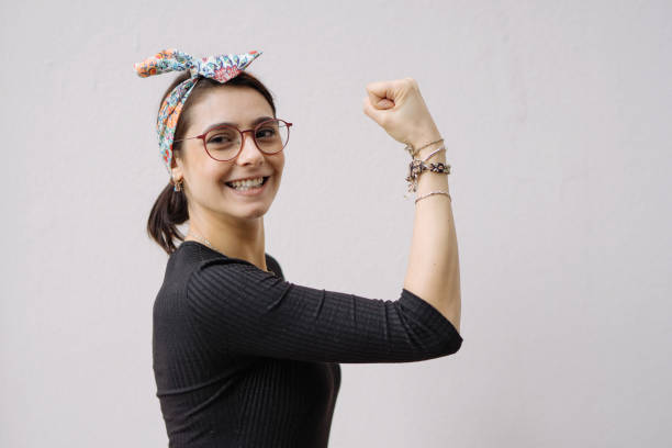 joven muestra su brazo fuerte - human muscle women bicep girl power fotografías e imágenes de stock