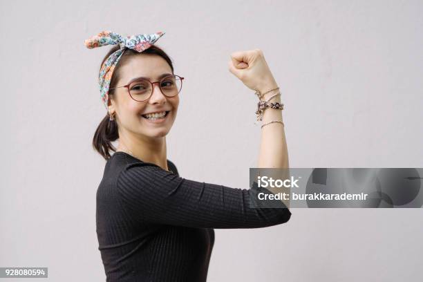 Young Woman Shows Her Strong Arm Stock Photo - Download Image Now - Girl Power, Flexing Muscles, One Woman Only