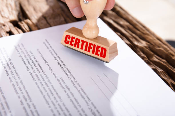 Person Holding Certified Stamp On Document Close-up Of A Person Holding Certified Stamp On Document Over Wooden Desk beatification stock pictures, royalty-free photos & images