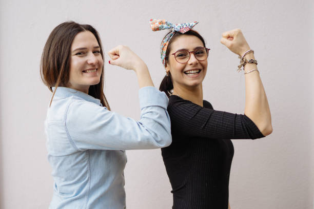 Two young women show their strong arms