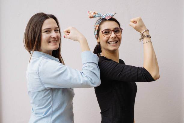 duas mulheres jovens mostram seus braços fortes - human muscle women flexing muscles female - fotografias e filmes do acervo