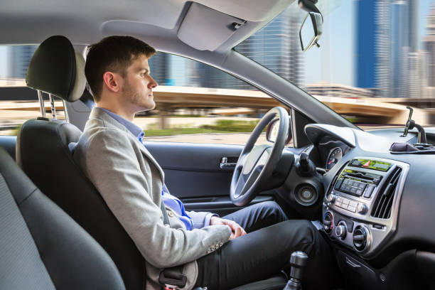 Man Sitting Autonomous Car Side View Of A Young Man Sitting Inside Autonomous Car driverless car stock pictures, royalty-free photos & images