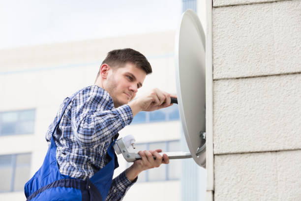 istock Man Fitting TV Satellite Dish On Wall 928081178