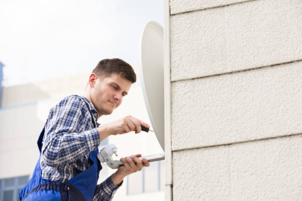 istock Man Fitting TV Satellite Dish On Wall 928081188