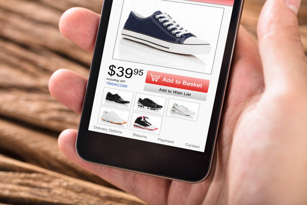 istock Person's Hand Holding Mobile Phone With Shopping Website 928081666