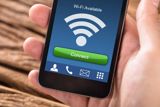 istock Person's Hand Holding Mobile Phone With WiFi Connection 928081676