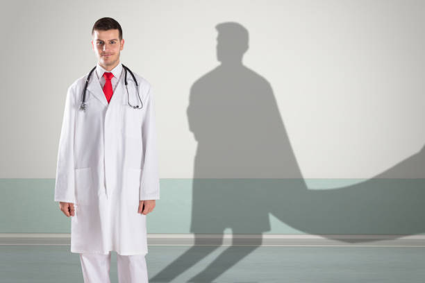 Young Happy Doctor With Superhero Shadow On Wall