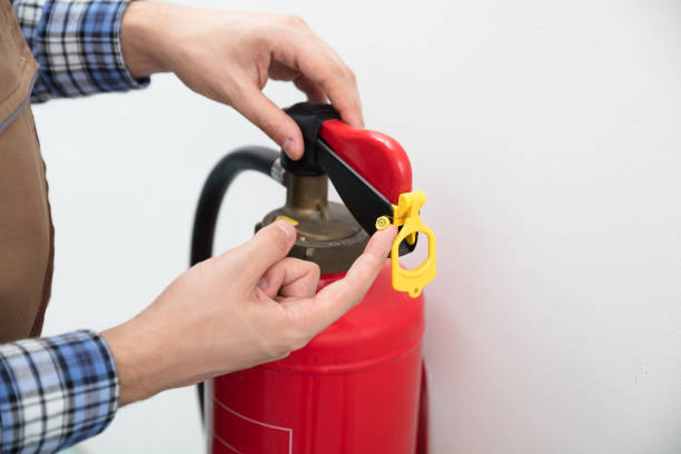 istock Technician's Hand Pointing To Symbol On Red Fire Extinguisher 928084112