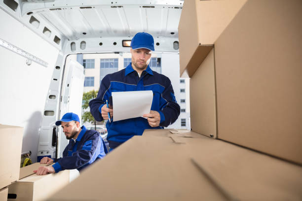 istock Mover Looking At His Partner Writing On Clipboard 928084776