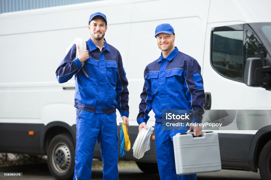 Lächelnde Mechaniker mit Werkzeugkiste und Kabel - Lizenzfrei Techniker Stock-Foto