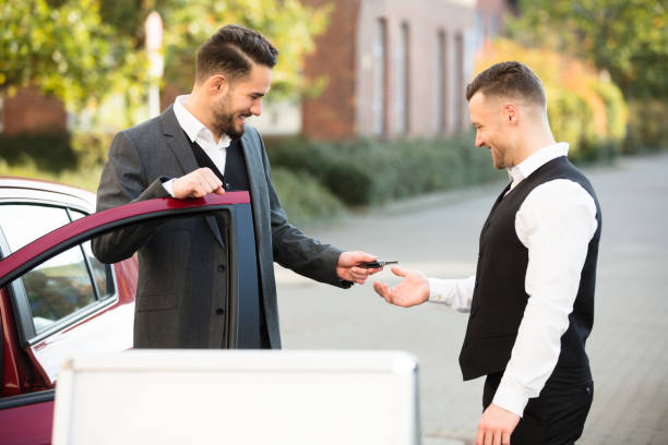 istock Young Businessman Giving Car Key To Valet 928085552