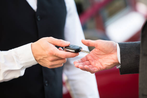 valet giving car key to businessperson - valet parking imagens e fotografias de stock