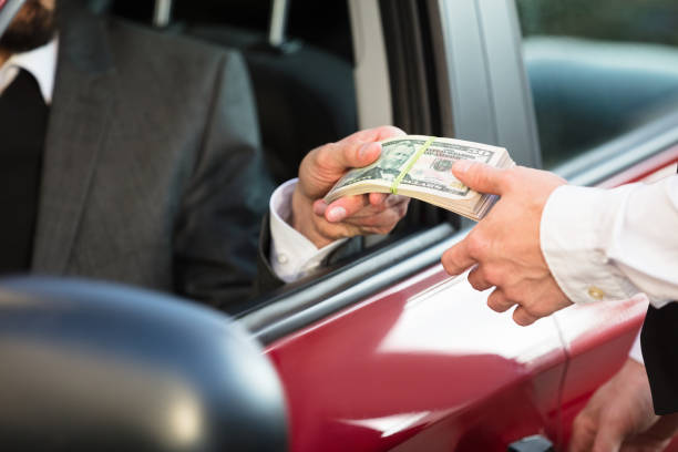 Businessman Giving Banknote To Person Businessman Sitting Inside Car Giving Bundle Of Banknote To Person cash for cars stock pictures, royalty-free photos & images