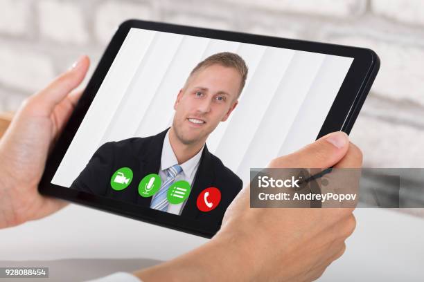 Businessperson Videoconferencing On Digital Tablet Stock Photo - Download Image Now - Video Call, Digital Tablet, Hand