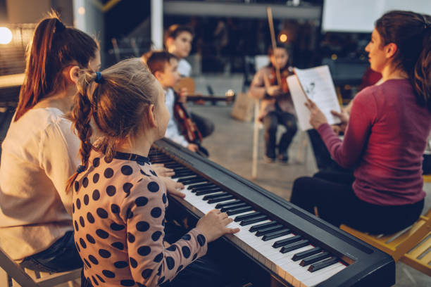Teaching to play music Group of kids teaching to play instruments in music school conservatory education building stock pictures, royalty-free photos & images