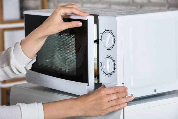 istock Woman's Hands Closing Microwave Oven Door And Preparing Food 928088928