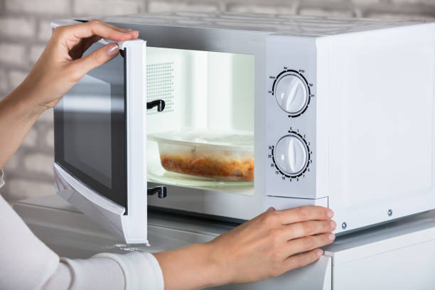 istock Woman's Hands Closing Microwave Oven Door And Preparing Food 928088938