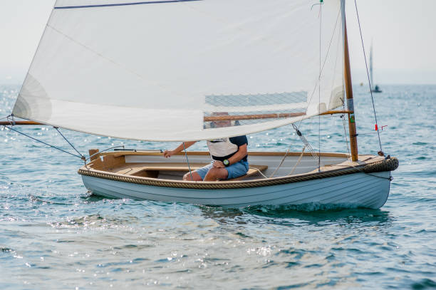 Subject: A young boy sailing on a small sail boat