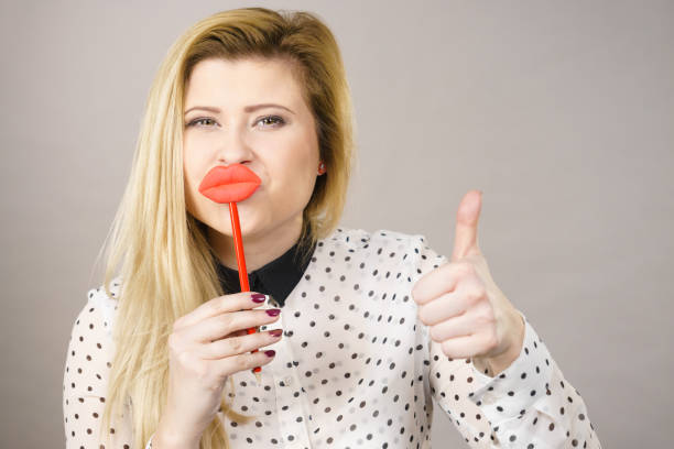 istock Happy woman holding fake lips on stick 928092246