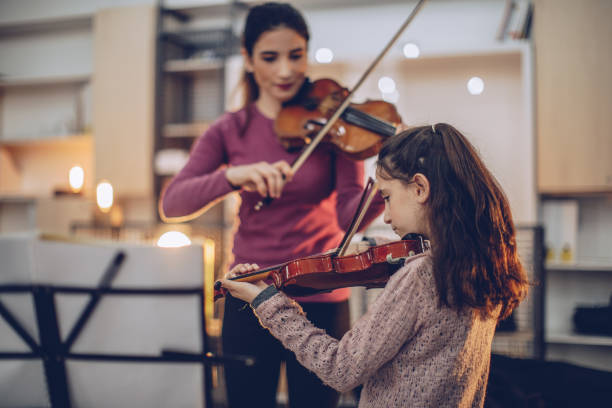 istock Girl teaching to play violin 928093796