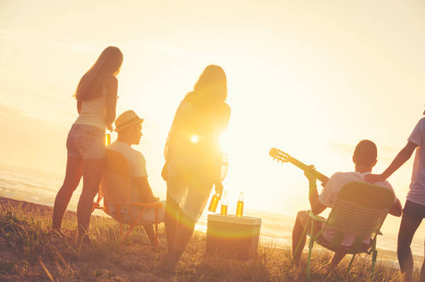 istock Relaxed friends beach party at sunset with 5 people. 928095270