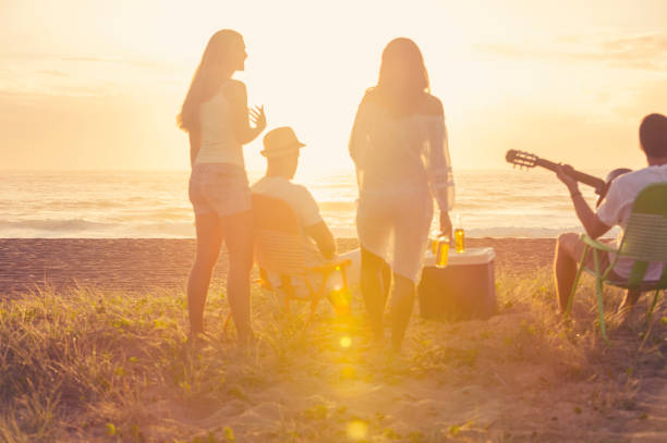 istock Relaxed friends beach party at sunset with 5 people. 928095272