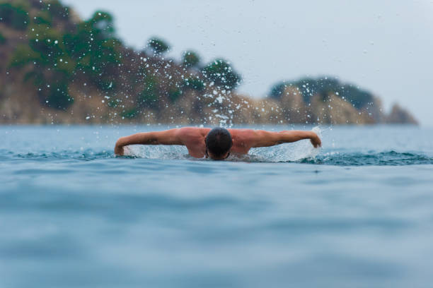 istock young sporting man swims in the sea dolphin style. 928096078