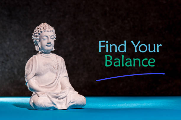 encuentra tu equilibrio - pequeño buda en postura de yoga - stone wellbeing zen like blue fotografías e imágenes de stock