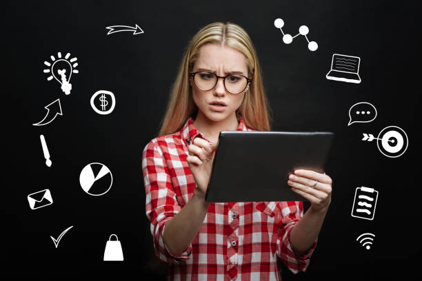 istock Surprised student frowning while looking at the screen of her tablet 928099872