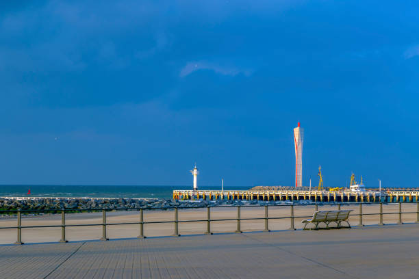 The cliff and the pier with lighthouse for big ships in Ostend, Belgium.