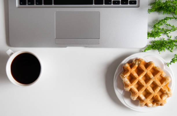 istock Notebook with hot coffee with wafer on wood table 928119766