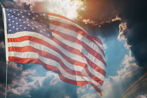 istock American flag flying, over beautiful Sunset sunrise with clouds, 928119932