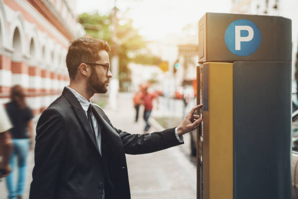 istock Businessman using Parking Meter outdoors 928134110