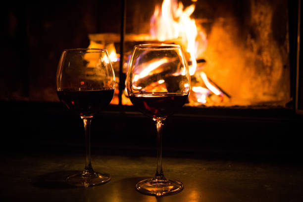 Pair of glasses with wine at fireplace nobody