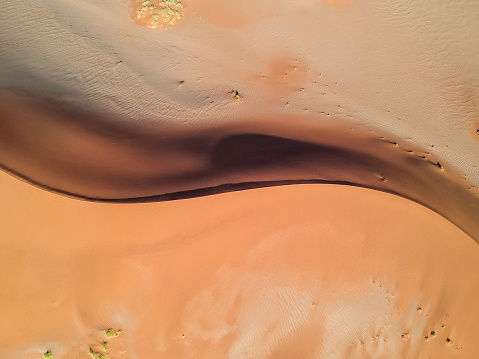 Stunning wide angle aerial drone view of a beautiful S shaped red sand dune at Sossusvlei near Sesriem in the Namib Desert of Namibia, Africa. Sossusvlei is a popular tourist destination.