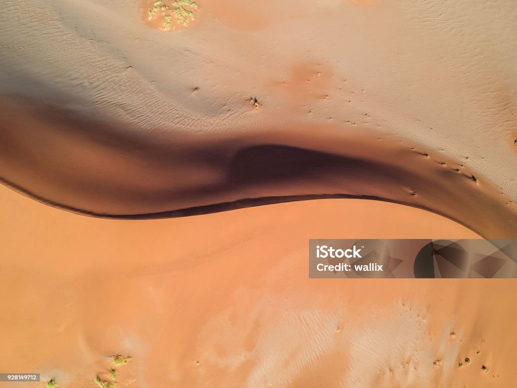 Uma deslumbrante vista de zangão aéreo grande angular de um bonito S em forma de dunas de areia vermelha em Sossusvlei perto Sesriem no deserto do Namibe da Namíbia, na África. Sossusvlei é um destino turístico popular. - Foto de stock de Vista Aérea royalty-free