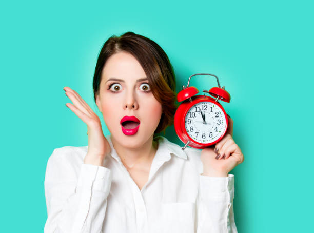 istock young woman with alarm clock 928153834