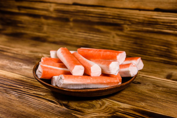 istock Ceramic plate with crab sticks on wooden table 928162288