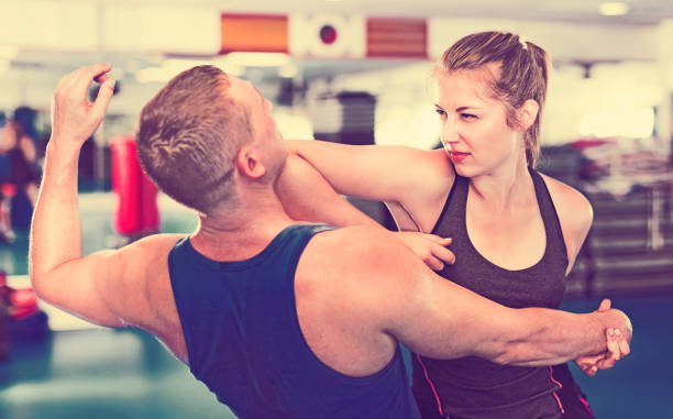 istock Woman is training with man on the self-defense course in gym. 928166144