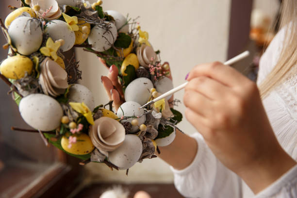 fille de peintures sur une couronne à la main avec oeufs de pâques. femme s’inspire des oeufs de pâques. préparation et célébration de la fête de pâques - easter rabbit bizarre women photos et images de collection